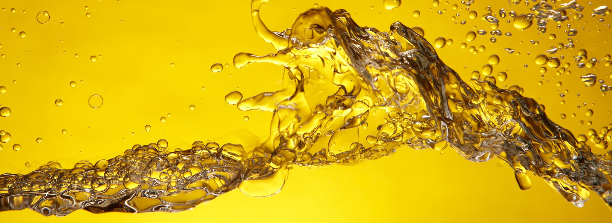 Artistic image with a yellow background of liquid used in biodiesel transportation splashing across screen