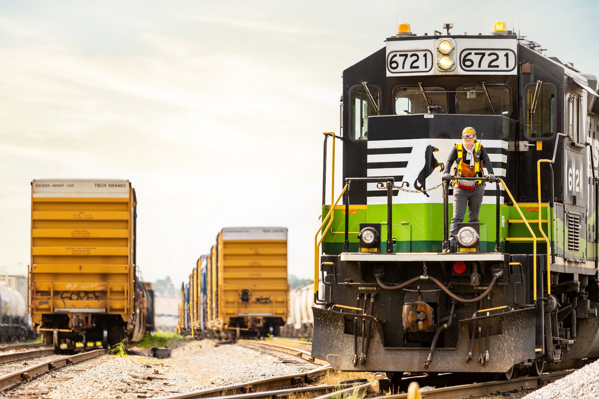 An employee stands proudly on railway tracks, proud of Norfolk Southern’s commitment to fostering an inclusive workplace culture. 
