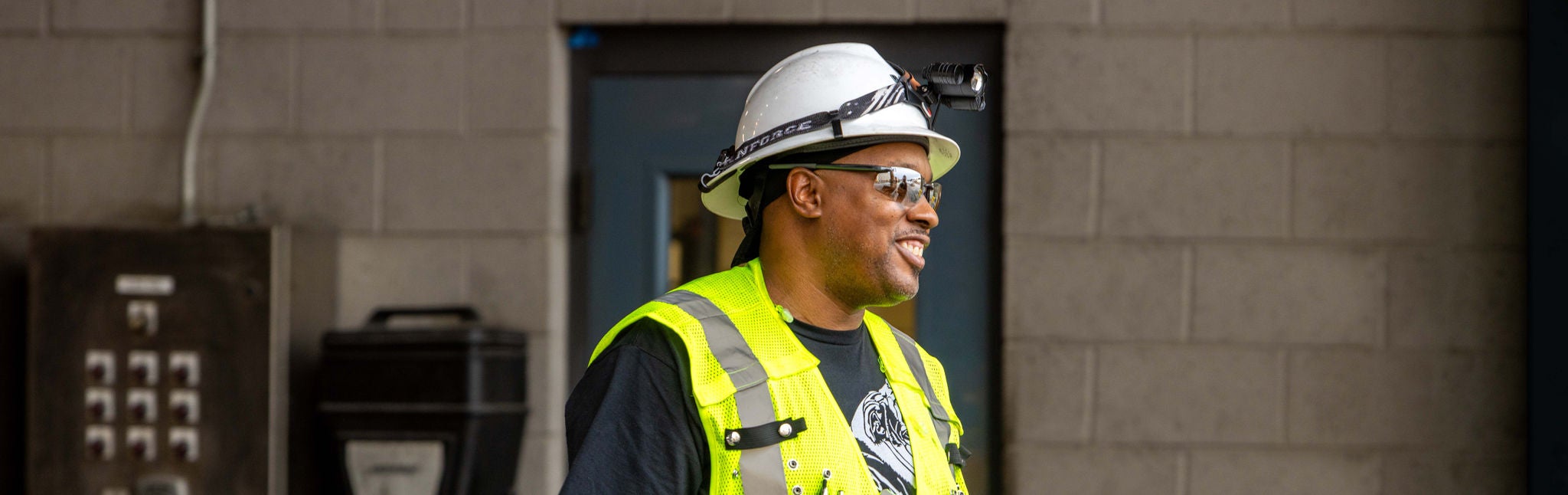 Norfolk Southern employee who uses safety technology in safety vest and hat smiling