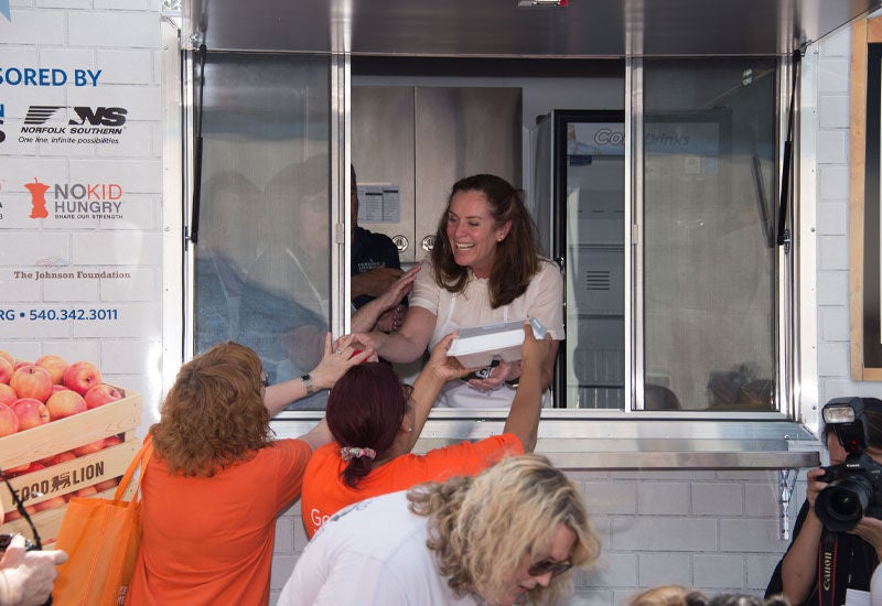 Man shaking hands of two people at a booth showing Norfolk Southern’s customer centric strategy