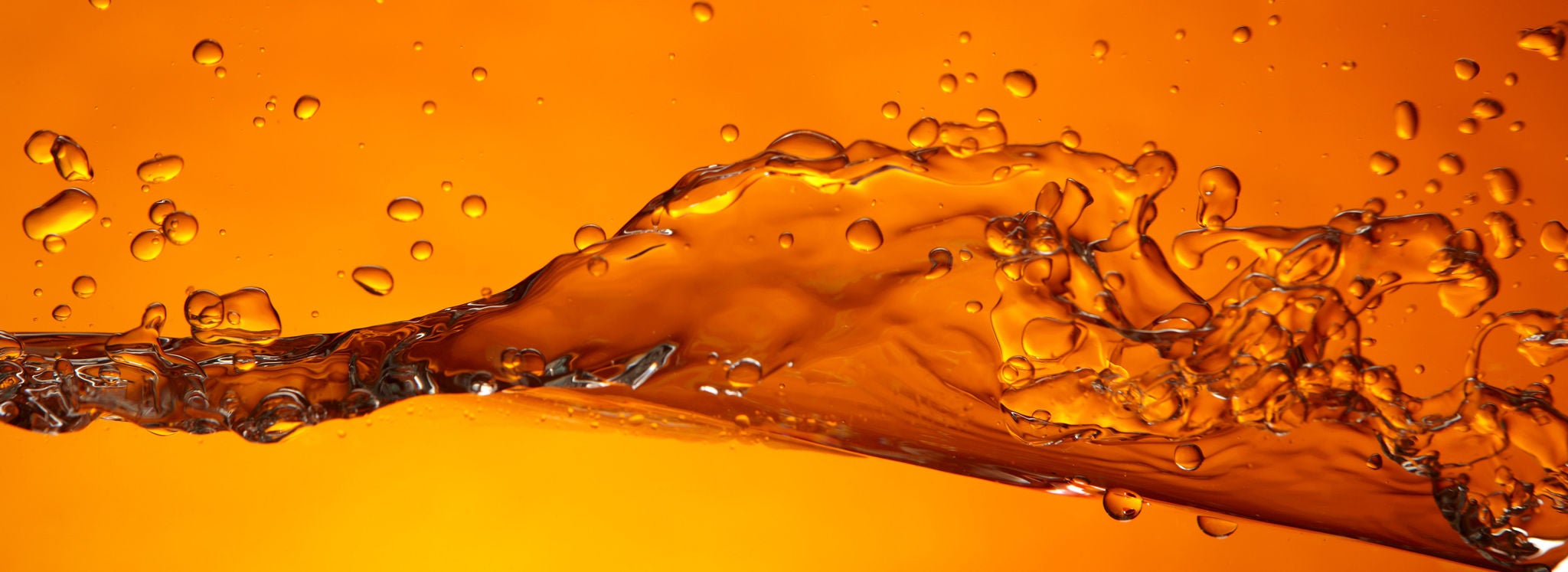 Artistic image with an orange background of liquid used in biodiesel transportation splashing