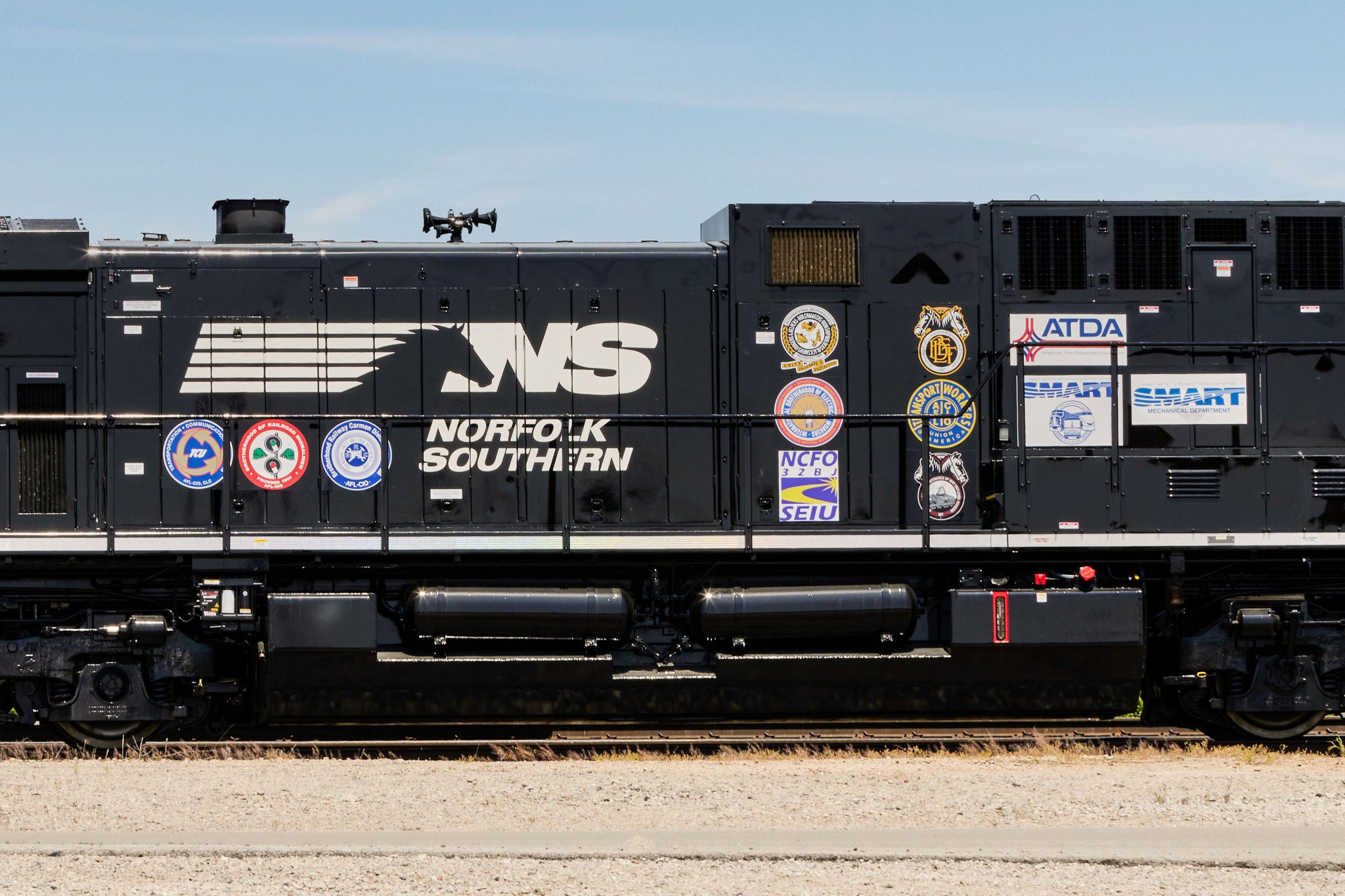 Norfolk Southern locomotive on track with logos of unions partnering together for better rail safety 