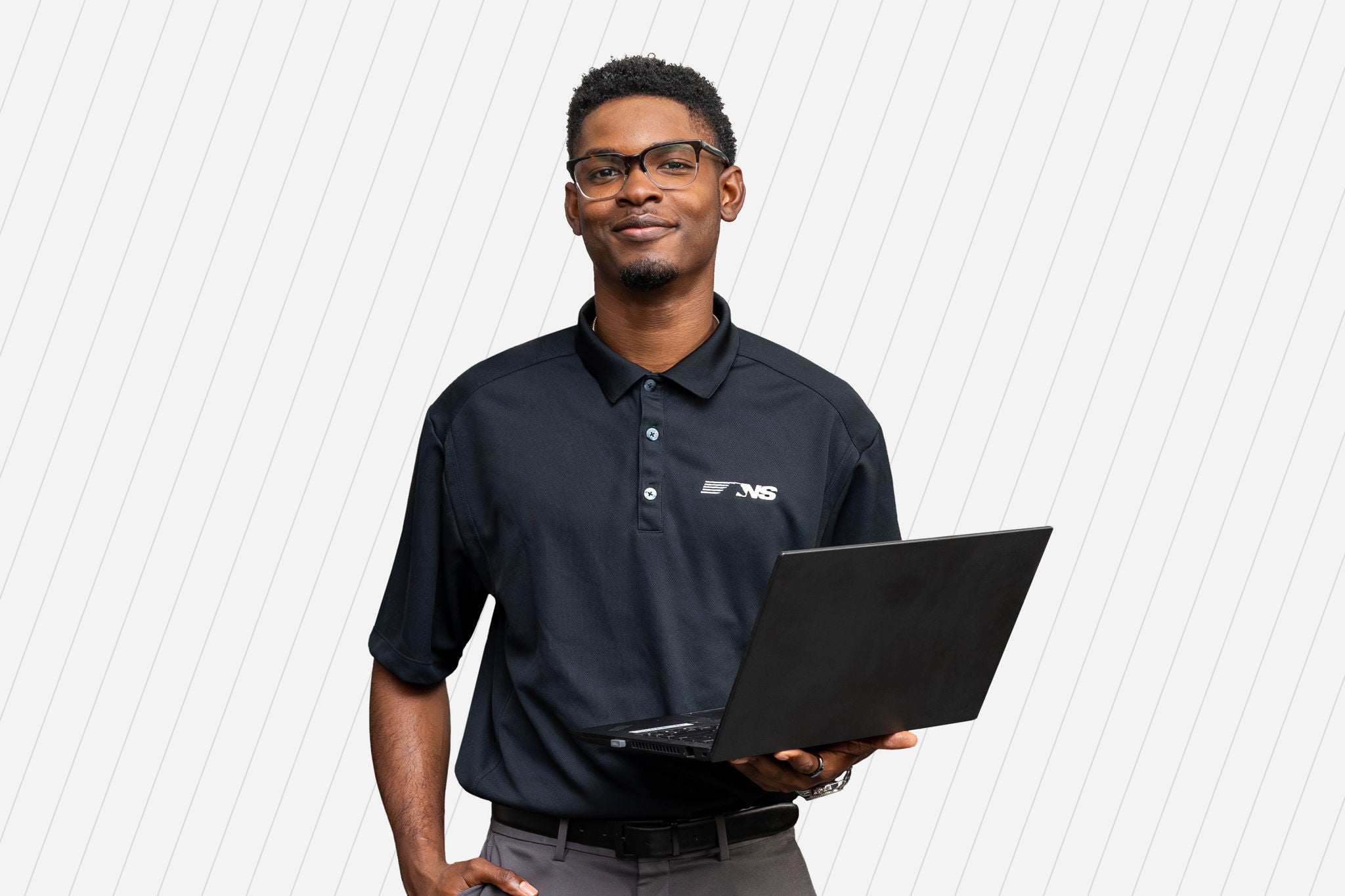 A Norfolk Southern technologist holds his computer and smiles thinking about the work he does on railway technology.