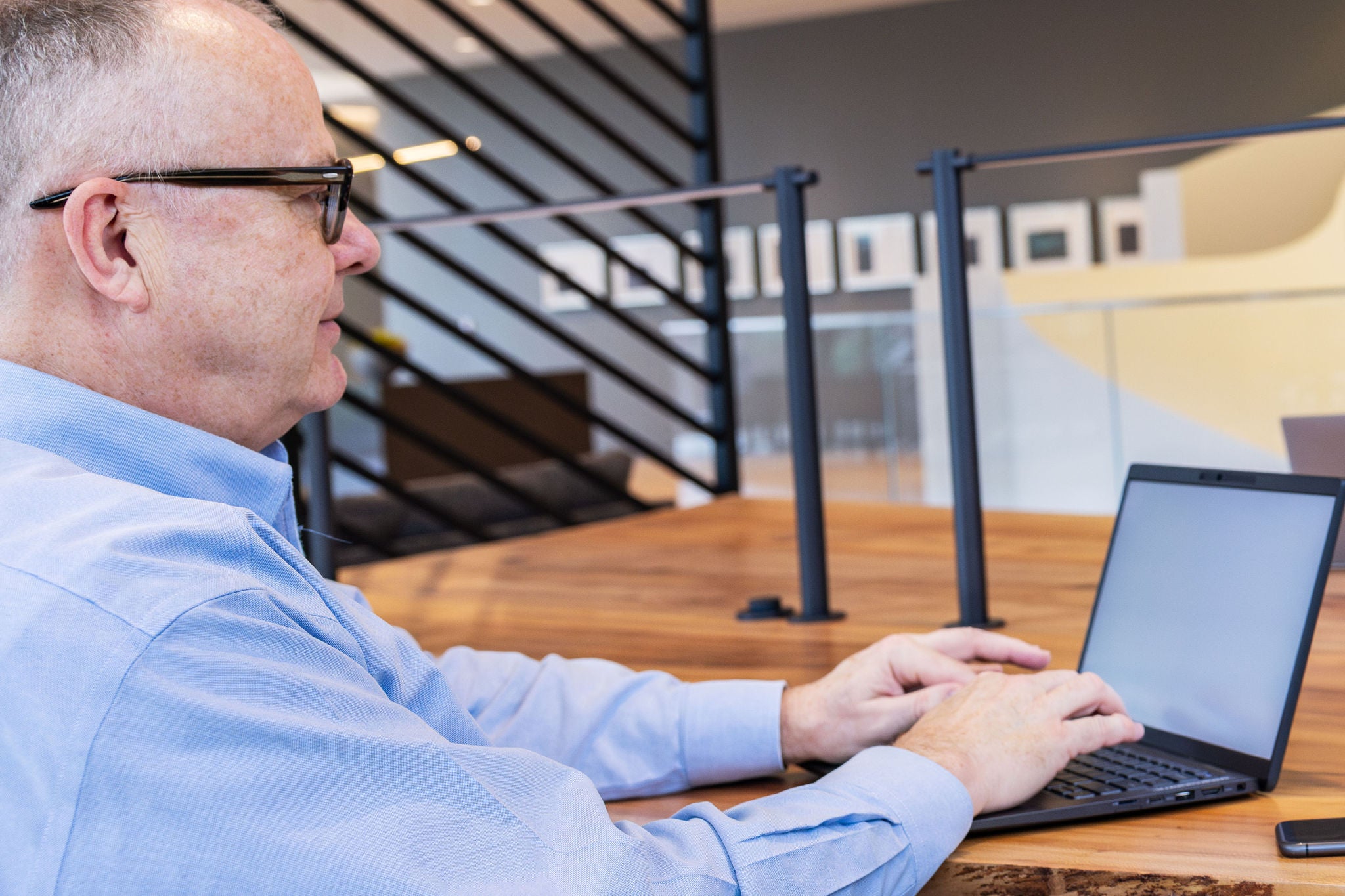 Man working on a laptop in an office setting reviewing a customer centric strategy