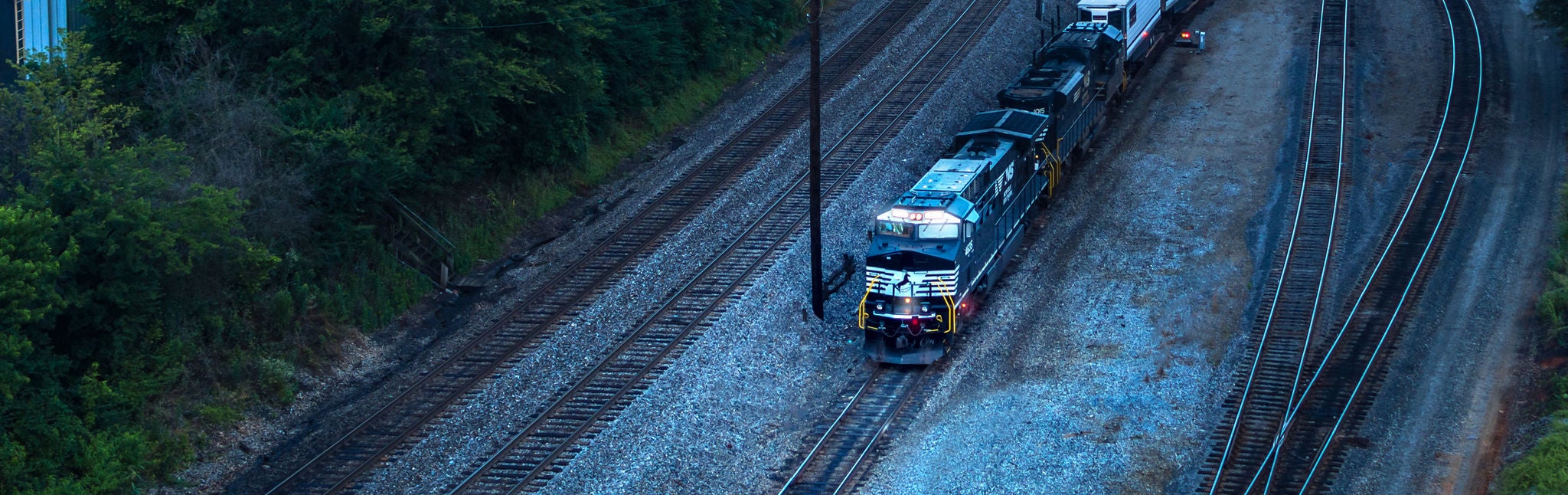 Aerial view of Norfolk Southern locomotive on railroad shipping agricultural products or industrial forest products.