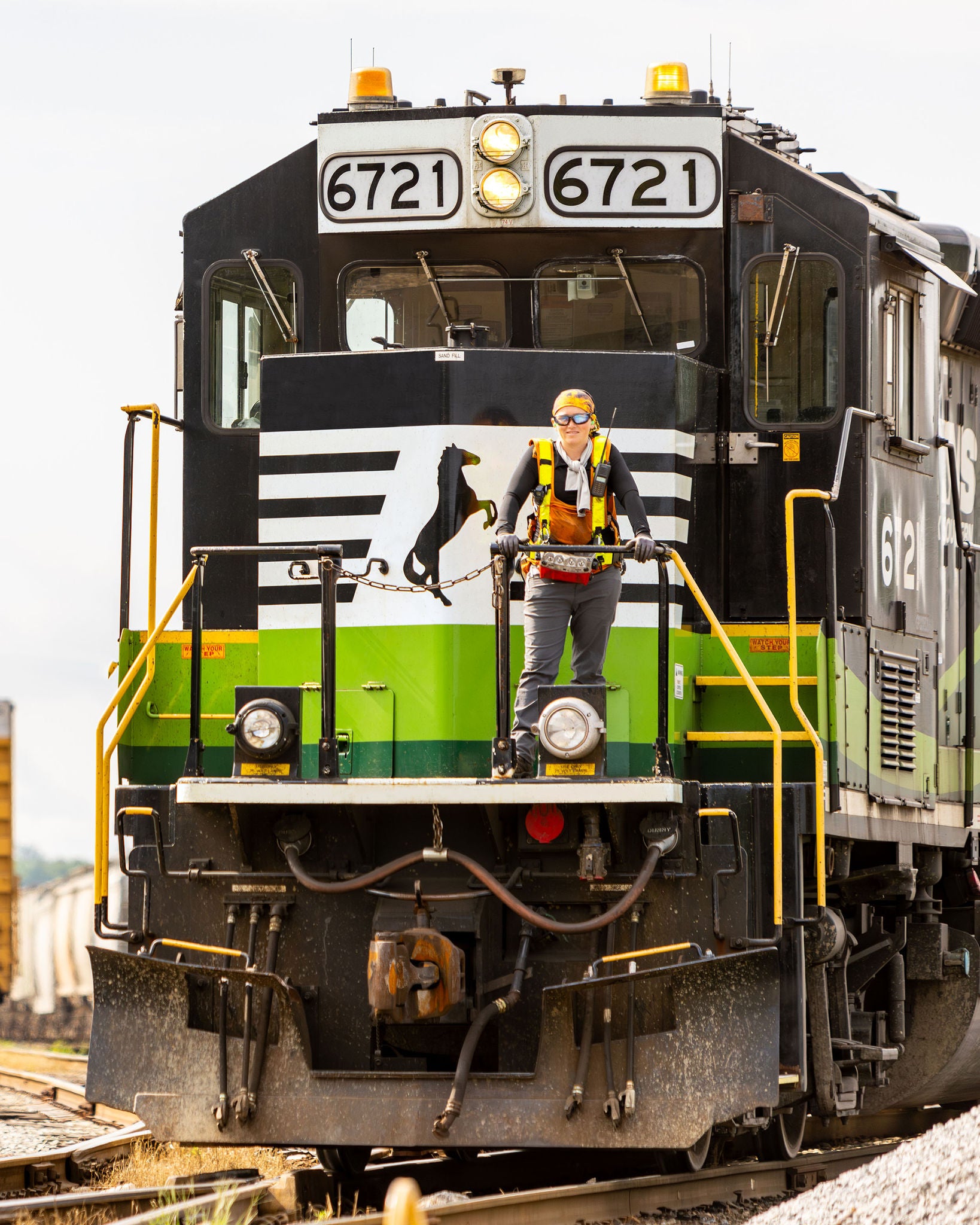 Person standing on the front of a Norfolk Southern eco train promoting community safety