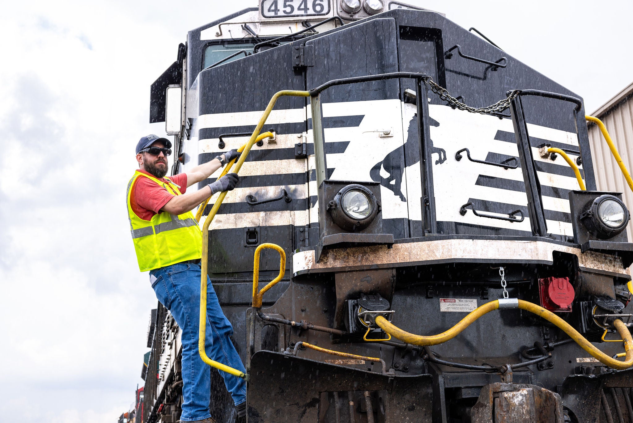 norfolk southern craft employee in railway job and dispatcher job holding on locomotive looking out