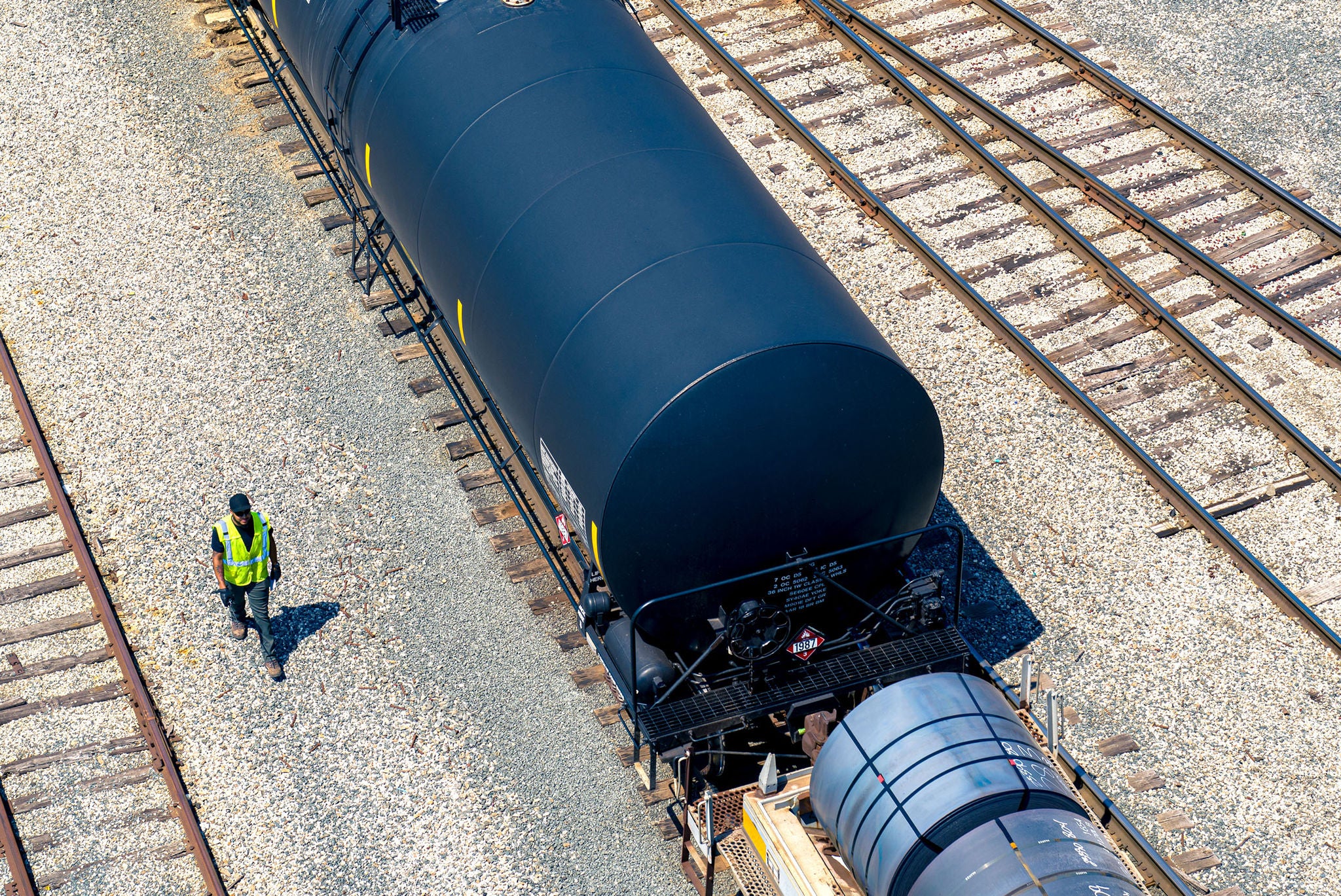 Aerial view of a tank car with a Norfolk Southern employee walking next encouraging you to find your shipping industry