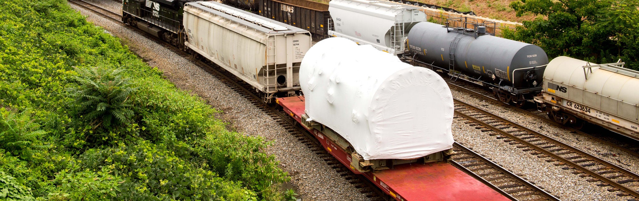 Large covered item on a train with oversize freight shipping options