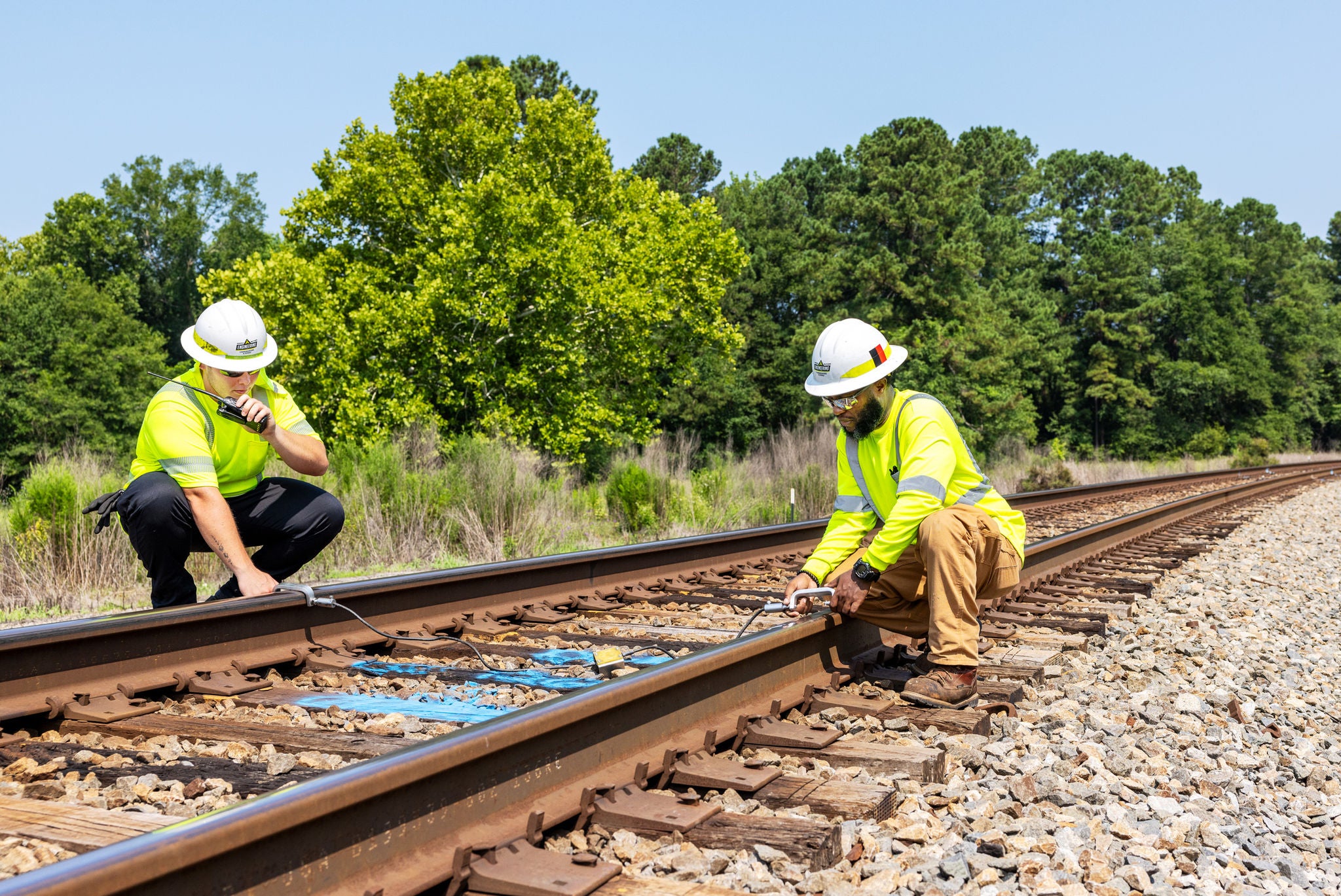 Two Norfolk Southern employees performing maintenance for better rail safety 