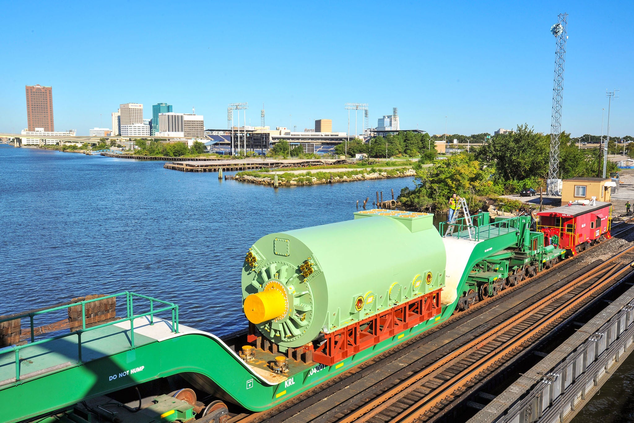 Large green metal part on an open flat car next to water showing ways to find your shipping industry