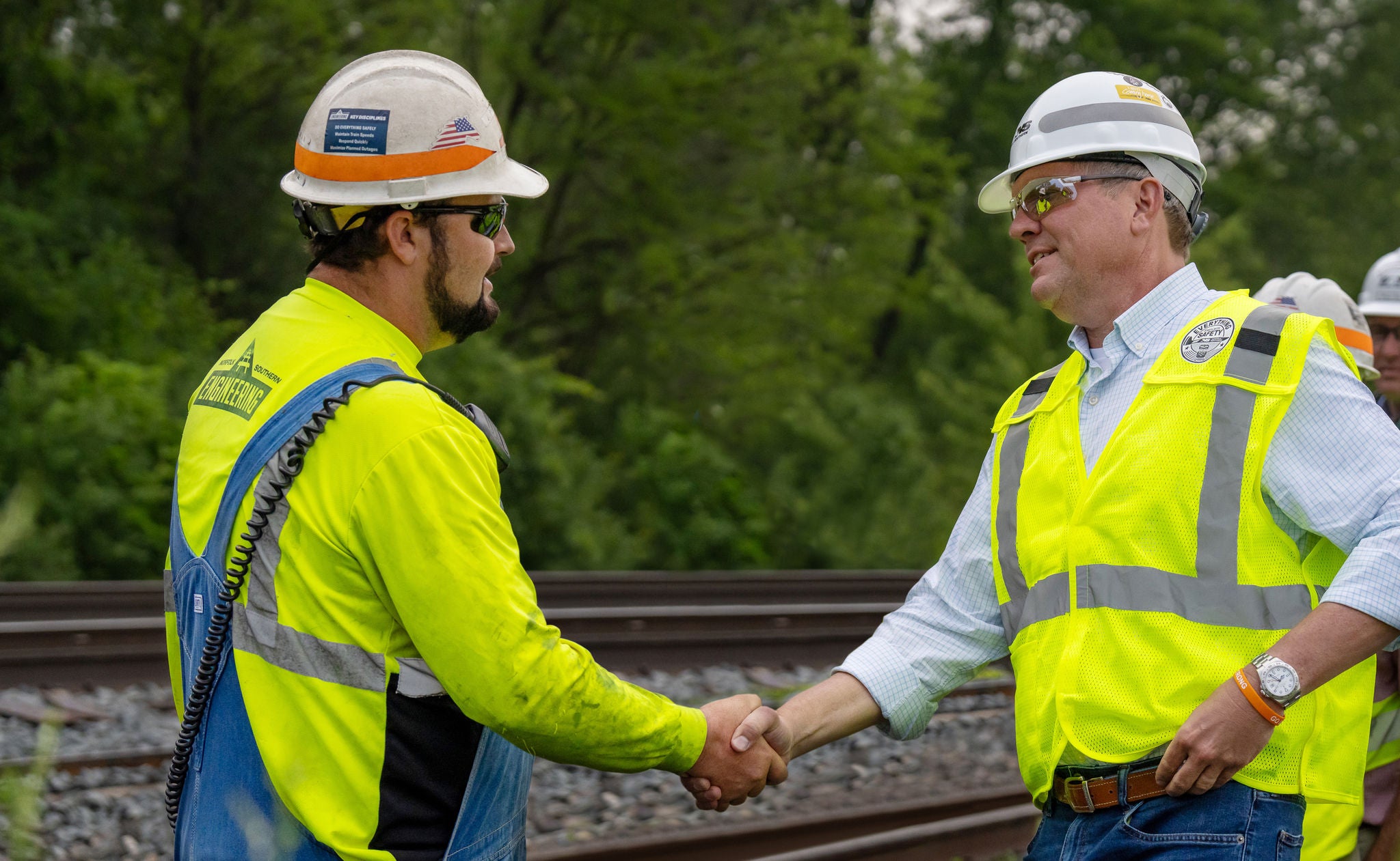 Front view of two Norfolk Southern transportation industry employees shaking hands