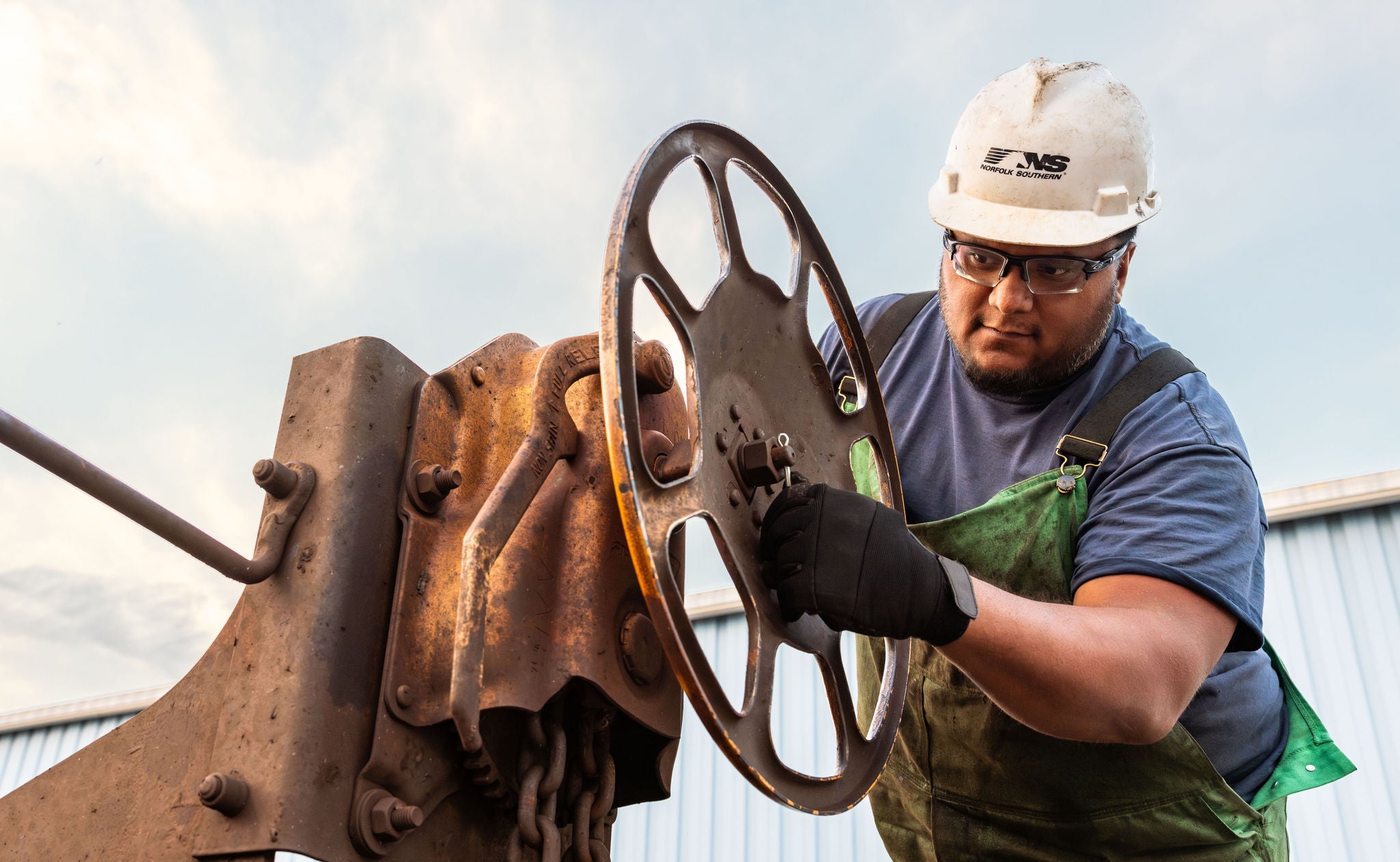 Norfolk Southern employee in hard hat tightening giant wheel showing a customer centric strategy in action