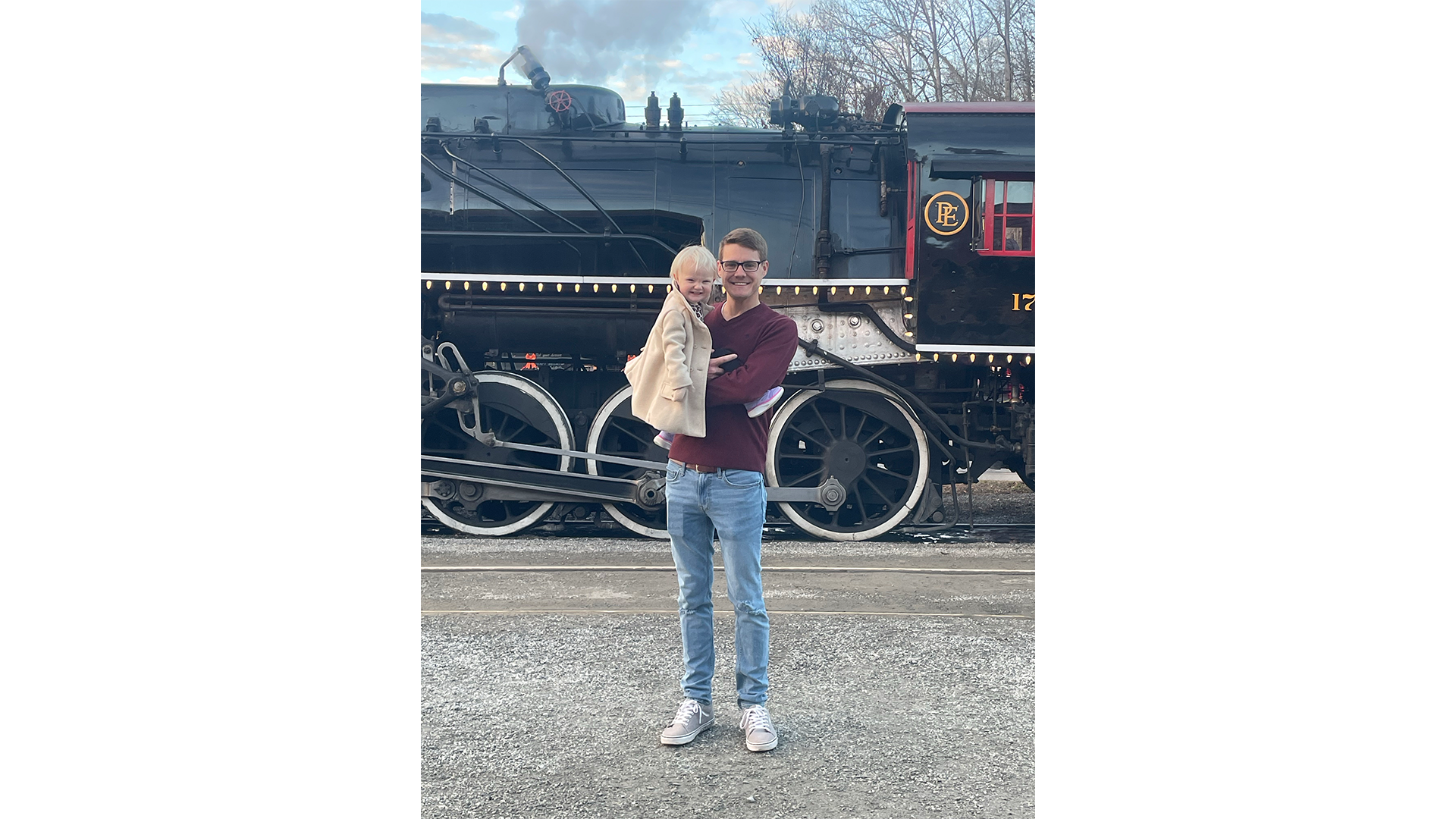 Brian holding daughter in front of train