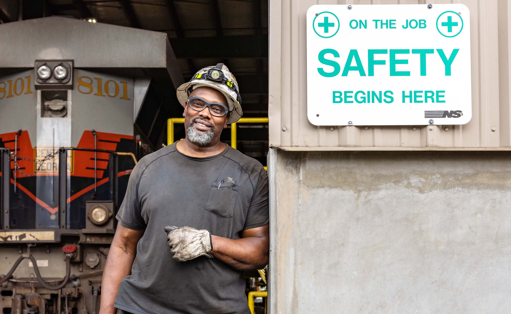 Norfolk Southern employee in repair shop promoting rail safety 