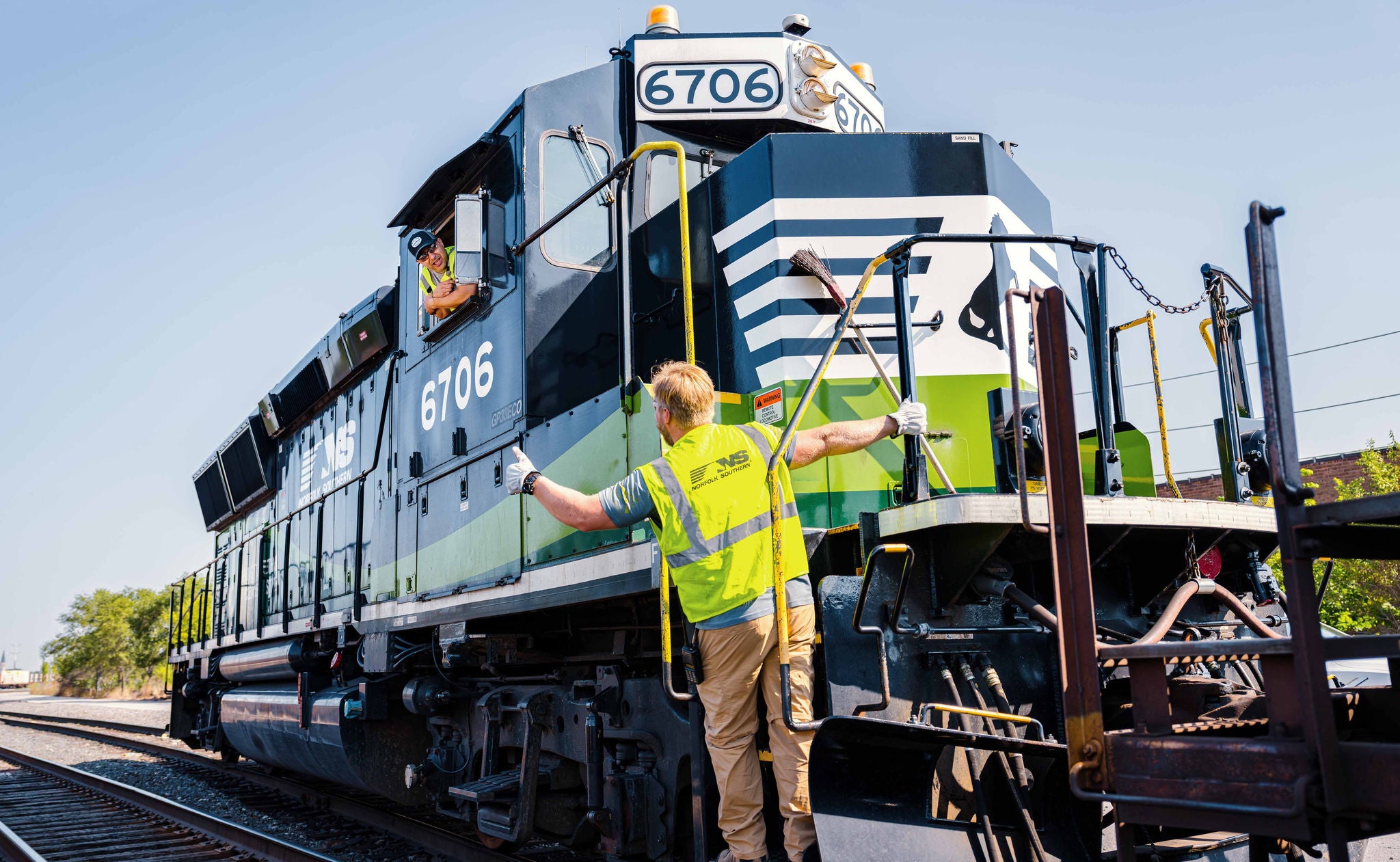  Low shot of Norfolk Southern employee riding front of eco train to improve sustainable rail transport