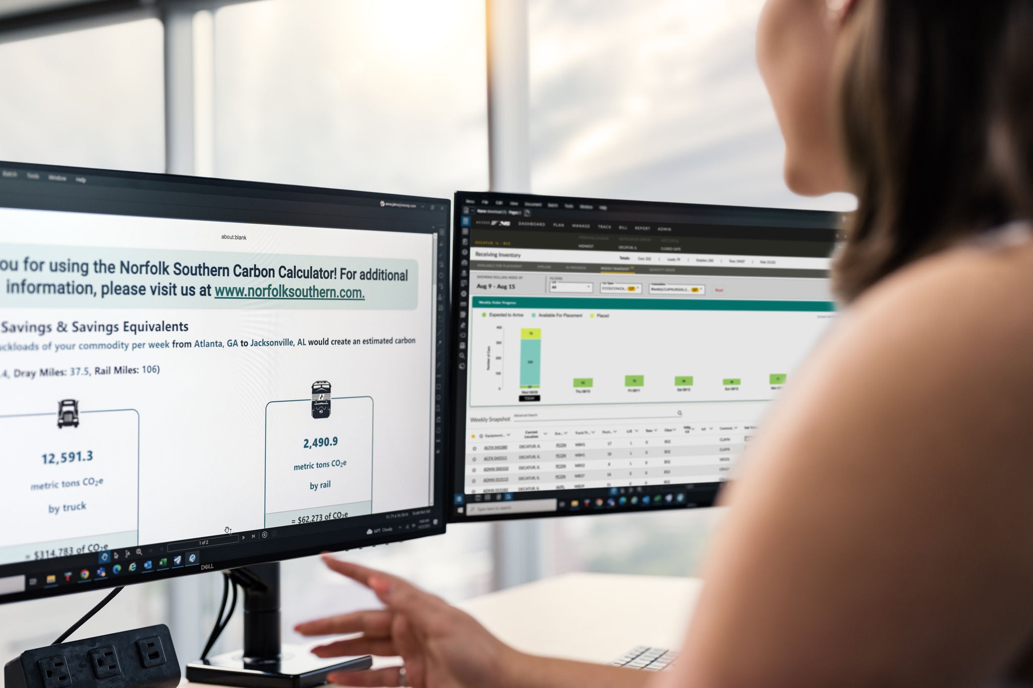 A Norfolk Southern employee reviews a dual monitor computer screen showing the railway company’s carbon calculator, an application aimed at making intermodal shipping services more efficient.