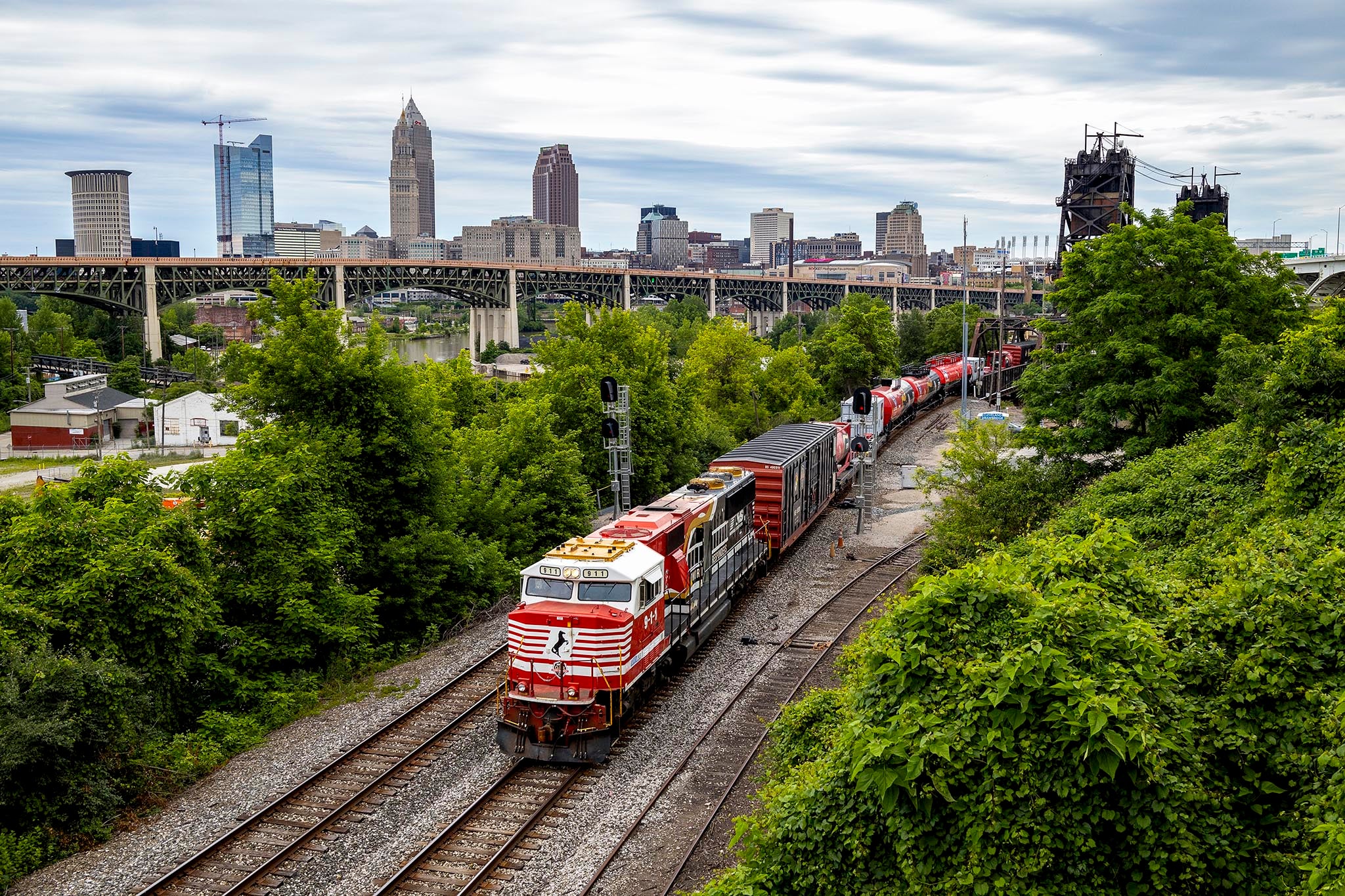 When conductor Steven Ludwick heard “The Safety Train”,would pass through Cleveland while he was visiting family,,he knew he had to photograph it.,“The Safety Train,” is part of Norfolk Southern’s Operation,Awareness & Response (OAR) program. This specially,outfitted train travels the country, educating local fire and,police departments on how to respond to rail emergencies,and hazardous materials incidents. Through the OAR,program, NS provides hands-on rail safety training to more,than 5,000 first responders across its network each year.,For Ludwick, the railroad has been a part of his life since,childhood. “My grandma got me into it, and both my,grandfather and uncle worked on the railroad,” he says.,His fascination with trains remains as strong as ever. “It’s,amazing how much weight trains can haul and how vital they,are to the world. The fact that so much power runs on two,steel rails just blows my mind.”,Photography has been a long-time hobby for Ludwick, who,also captured the back cover photo of this year’s calendar,,which showcases a coal train climbing a steep hill in Kings,Mountain, Kentucky. The OAR train pictured here is passing signal masts, after crossing a lift bridge outside of Cleveland, Ohio. The city skyline is visible in the background, Steven Ludwick 2025 Calendar Contest Entry