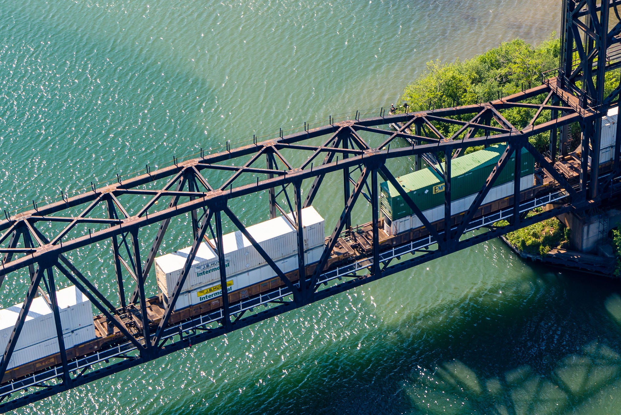 Intermodal train cars cross water on bridge encouraging you to find your shipping industry