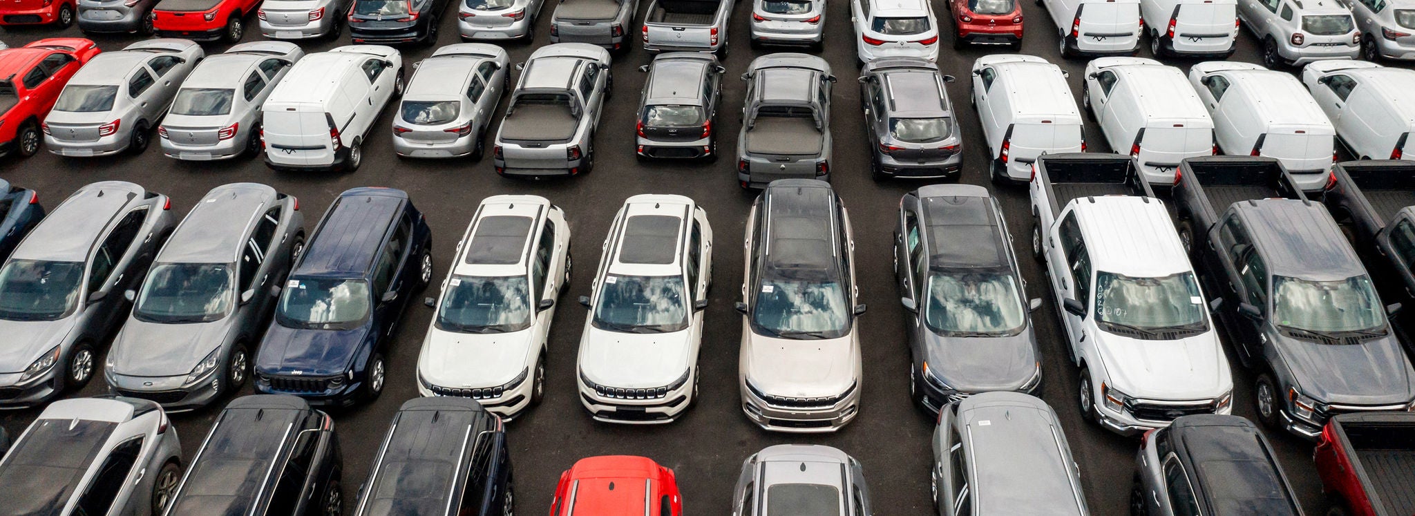 An aerial shot of finished vehicles parked on an automobile transport rail.