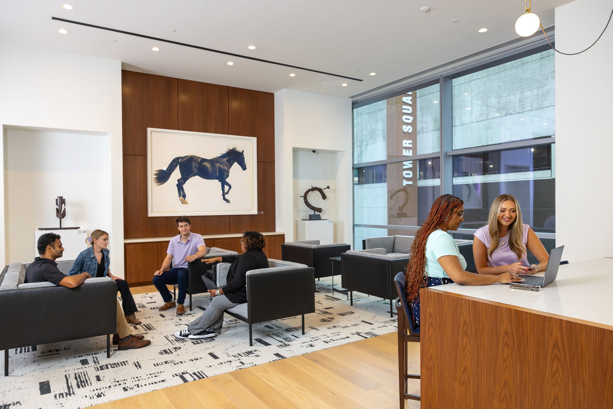 A diverse group of employees sitting around an open area in Norfolk Southern headquarters demonstrate  the inclusive workplace culture. 