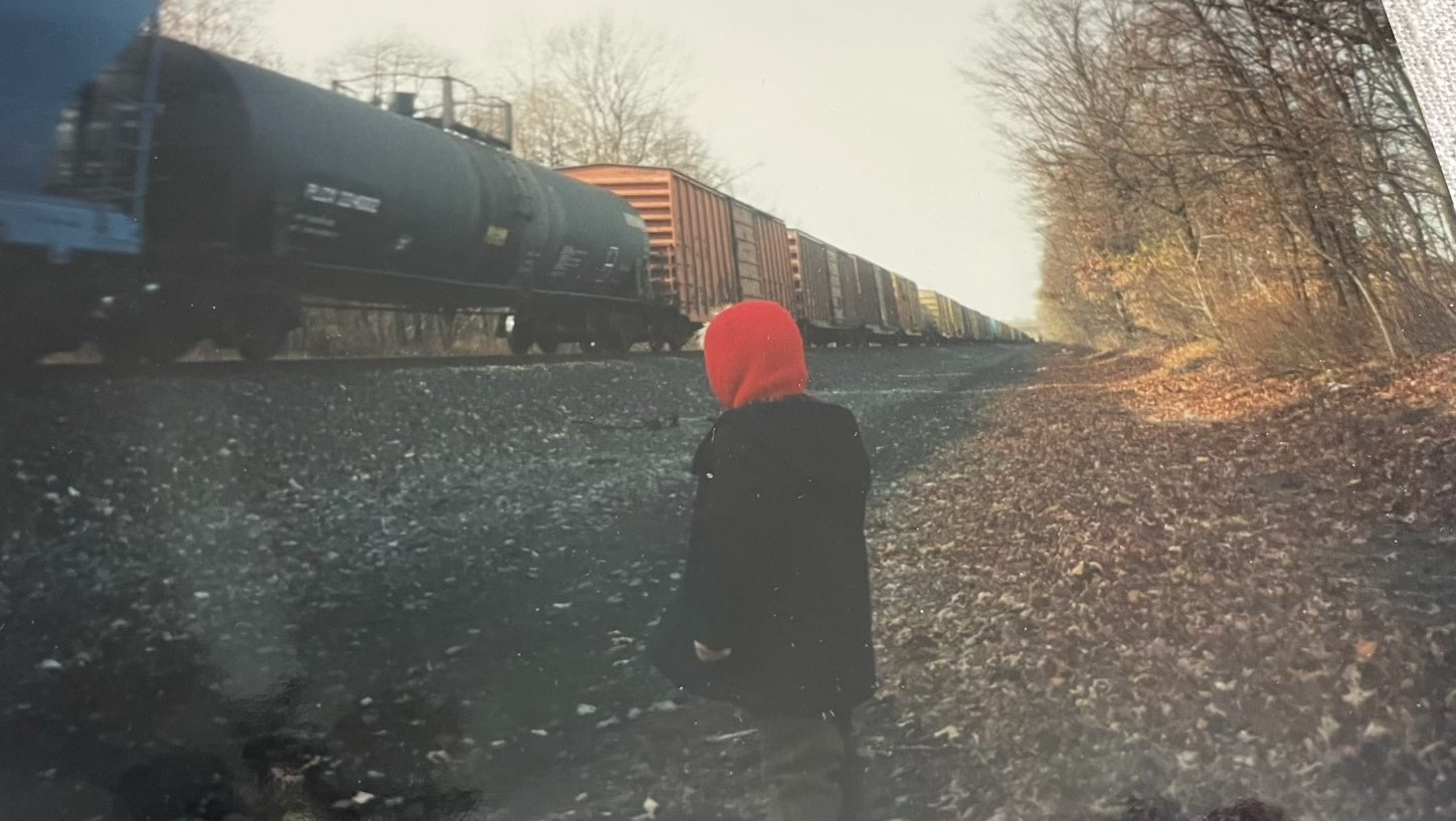 Young Brian watches a passing train