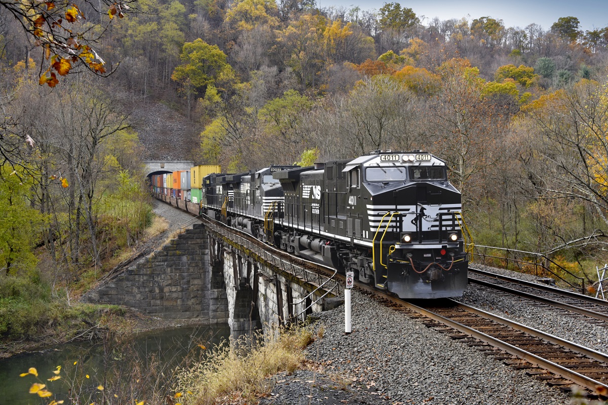 Photography and railroading go well together. One seems to complement the other — and for Locomotive Engineer Lance Myers, he’s often on both sides of the coin.,“I’ve been with NS for 15 years,” Myers says. “I started as a conductor trainee and made my way to conductor and then locomotive engineer. I’m proud of the work that I do, and enjoy catching our trains in action through photography when I’m not on the job.”,In one of those moments, Myers caught an NS double-stack intermodal train exiting the Spruce Creek Tunnel along the Juniata River in Pennsylvania. Led by one of our DC-to-AC converted locomotives, this train is moving international containers bound for New Jersey on our Premier Corridor.,Myers’ railroading career has been spent based in Altoona, Pennsylvania, where he operates road trains to and from Harrisburg and Pittsburgh, Pennsylvania. He frequently serves on a crew known as the Altoona Helpers, assisting NS trains over steep grades of the Allegheny Mountains.