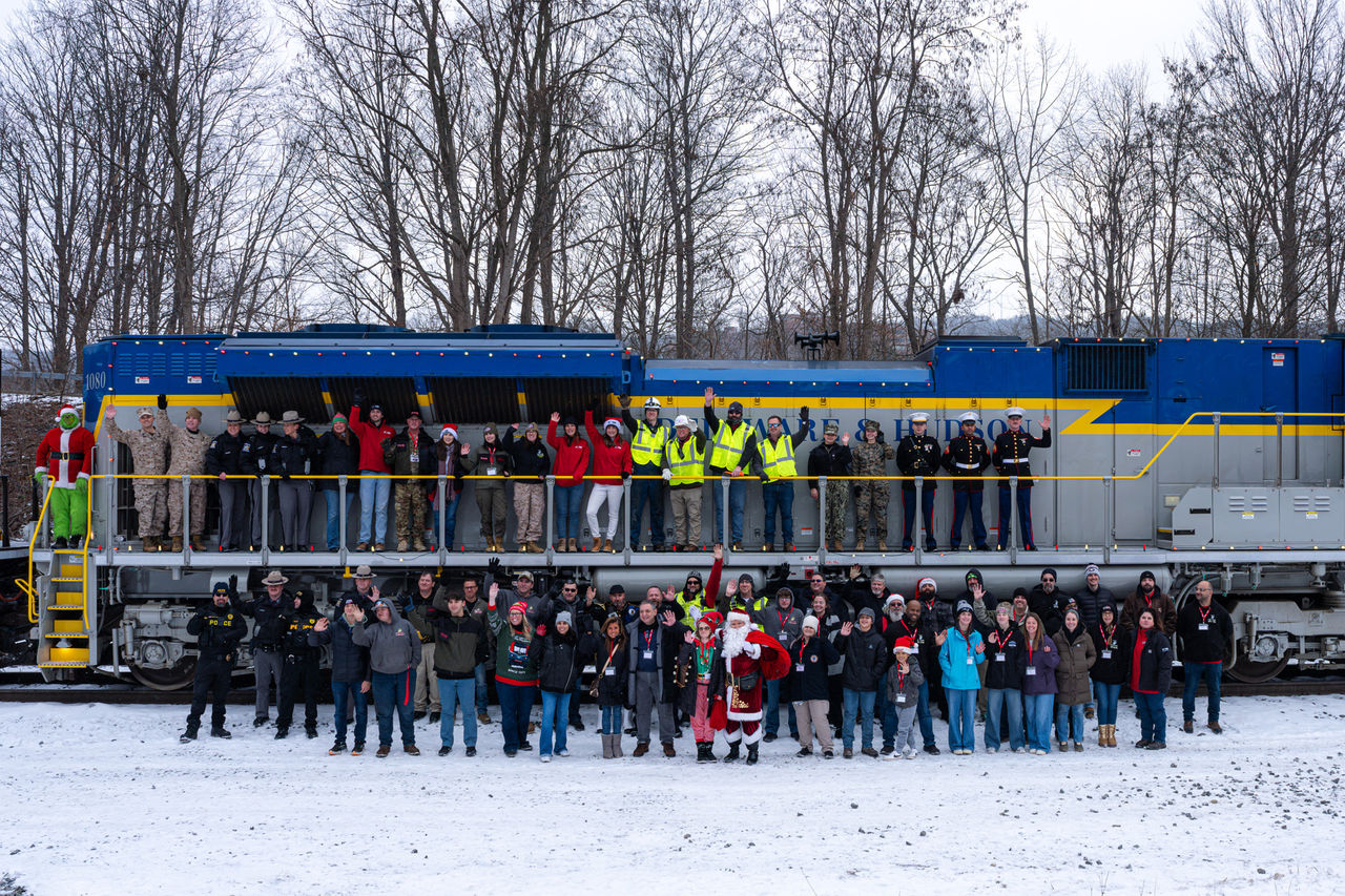 Group photo in front of train at Toys for Tots Holiday Train event