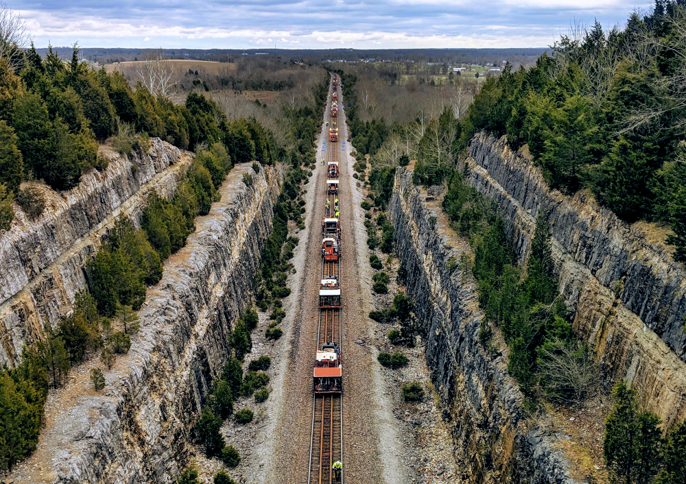 A Norfolk Southern dual-rail gang works through miles of track that pass through a rocky crevice in DePauw, Indiana.